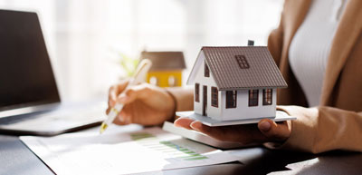An investor holding a model of a house