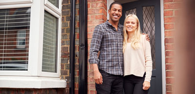 A young couple outside a home