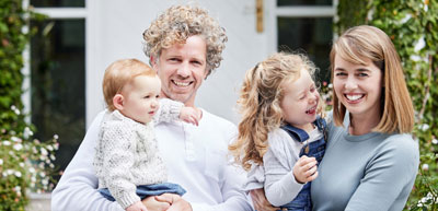 A young family outside their home